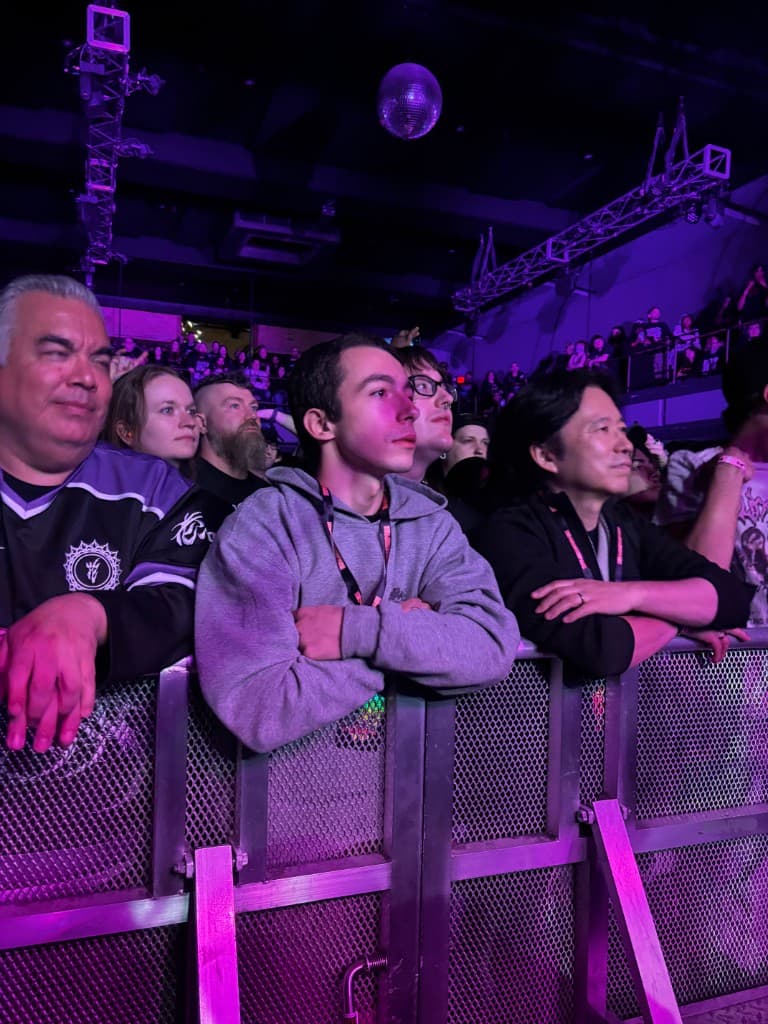 Fans at the front row of a concert, focused on the performance
